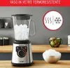 A blender filled with ice sits on a wooden countertop, with a bowl of ice and a fruit basket in the background. Voir les images du produit