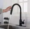 A hand is shown operating a black kitchen faucet with water running into a sink. Produktbild-Vorschau