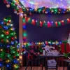 A decorated outdoor space for a Christmas party with a tree, lights, and a banner. Produktbild-Vorschau