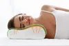 A woman is sleeping peacefully on a pillow, with the pillow's supportive features highlighted by orange arrows. Produktbild-Vorschau