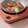 A close-up shot of an induction cooktop with a pan of food on it, featuring a digital display and control buttons. A graphic overlay highlights a feature. Voir les images du produit