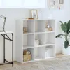 A white cube bookshelf filled with books and decorative items, placed in a room with a desk and a plant. Produktbild-Vorschau
