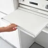 A hand is pulling out a white drawer from a kitchen appliance. Podgląd zdjęcia produktu