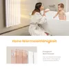A woman and a baby in a bathroom, with a radiator in the background. Produktbild-Vorschau