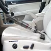 A handheld vacuum cleaner is being used to clean the interior of a car, specifically the car seat. Produktbild-Vorschau