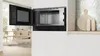 A built-in Bosch microwave oven with its door open, showing the interior. The kitchen setting is visible in the background. Voir les images du produit