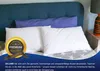 Two white pillows are displayed on a bed with a blue headboard and a purple bolster pillow. Produktbild-Vorschau
