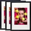 Three black picture frames are displayed side-by-side, with the middle frame showcasing a young woman holding tennis balls with smiley faces drawn on them. Produktbild-Vorschau