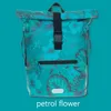 A roll-top rucksack with a tropical floral pattern against a solid teal background. Produktbild-Vorschau