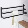A black three-tier towel rack mounted on a white wall, with two towels hanging on the middle and bottom racks. Anteprima dell’immagine prodotto