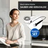 A woman is washing dishes in a kitchen, with a product image overlay showing a sink drain assembly. Produktbild-Vorschau