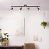A ceiling spotlight is installed on a white ceiling above a painting and a plant. Produktbild-Vorschau