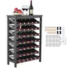 A black wine rack filled with wine bottles, with two wine glasses and a bowl of fruit on top. Náhľad obrázku produktu