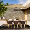 An outdoor dining set with a rectangular umbrella, table, and chairs on a stone patio. Produktbild-Vorschau