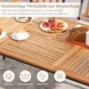 A close-up view of a wooden outdoor table set for breakfast, with food and drinks on it. Produktbild-Vorschau