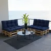 A balcony with a view of the ocean, furnished with pallet furniture and cushions. Voir les images du produit