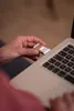 A person's hand is holding a small gold flashlight and inserting it into a laptop. Anteprima dell’immagine prodotto