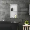 A modern bathroom with a black bathtub, a built-in shower niche with toiletries, and a small stool with a plant. Náhľad obrázku produktu