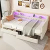 A white daybed with tufted detailing, LED lighting, and storage drawers, styled with pillows and blankets. Náhled obrázku produktu