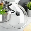 A glass lid for a pot is shown in focus, with pots and a plant in the background. Podgląd zdjęcia produktu