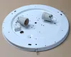 A white circular ceiling light fixture base with two light bulb sockets and a wiring connector block. Produktbild-Vorschau