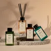 Four bottles of home fragrance diffusers are arranged on textured stone blocks against a soft, gradient background. Podgląd zdjęcia produktu