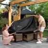 A couple is covering an outdoor lounge set with a black protective cover. Náhľad obrázku produktu