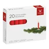 A box of red chime candles with a sprig of evergreen and a lit candle. Produktbild-Vorschau
