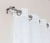 A close-up view of a silver curtain rod with white curtains hanging from it. Produktbild-Vorschau