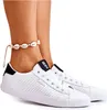 A close-up shot of a pair of white leather sneakers with black accents, worn by a person with a seashell anklet. Podgląd zdjęcia produktu