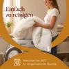 A woman is holding a white duvet in front of a washing machine, suggesting it is easy to clean. Podgląd zdjęcia produktu