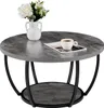 A round, two-tiered coffee table with a gray wood-grain finish and black metal legs, displayed on a white background. A white vase with flowers and a cup of coffee on a magazine are placed on the tabletop. Voir les images du produit