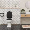 A modern bathroom with hexagonal tiles, a toilet, and a vanity. Produktbild-Vorschau