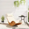 A wooden rocking lounge chair with a beige cushion sits on a balcony next to a small table with a vase of flowers and two cups. Anteprima dell’immagine prodotto