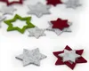 A collection of felt star-shaped confetti in red, green, and gray colors, scattered on a white background. Produktbild-Vorschau