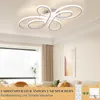 A modern living room with a stylish ceiling light, large window, and sofa. Podgląd zdjęcia produktu