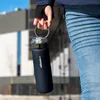 A person holding a water bottle outdoors. Náhled obrázku produktu