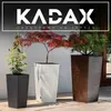 Three tall planters with plants in them, placed outdoors on a patio. Podgląd zdjęcia produktu