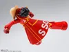 A toy action figure of Monkey D. Luffy from One Piece, dressed in a red outfit with yellow trim and the letters 'SSG' on it. The figure is in a dynamic pose, as if in motion. Podgląd zdjęcia produktu