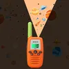 A toy walkie-talkie is shown projecting an image of planets and comets into a dark background with a starry pattern. Náhľad obrázku produktu