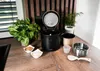 A rice cooker and its accessories are displayed on a wooden countertop. Voir les images du produit