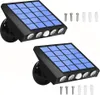 Two solar-powered LED lights with solar panels and multiple LED bulbs, along with screws and wall anchors. Produktbild-Vorschau