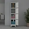 A tall, gray metal locker unit with four open doors, displaying various items inside, set against a plain gray wall. Anteprima dell’immagine prodotto