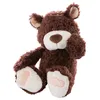 A brown teddy bear is sitting with its legs extended and one paw raised to its face. Podgląd zdjęcia produktu