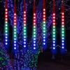 Christmas lights hanging from trees at night. Produktbild-Vorschau