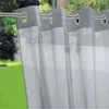 Outdoor curtains hanging on a rod, with a blurred green garden background. Anteprima dell’immagine prodotto