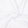 A close-up, top-down view of a white fabric, likely a scarf or shawl, with soft folds and creases. Anteprima dell’immagine prodotto