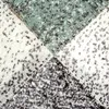 A close-up view of a carpet with an abstract geometric pattern. Produktbild-Vorschau