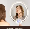 A woman is looking into a round LED mirror with condensation on it. A finger is touching a touch-sensitive button on the mirror. Anteprima dell’immagine prodotto