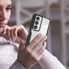 A woman is holding a smartphone with a black and clear case, looking at the screen. Produktbild-Vorschau